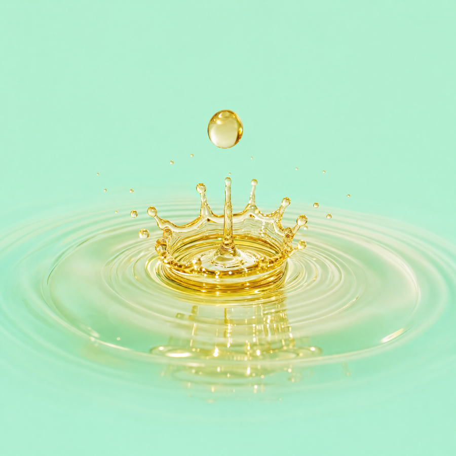 Goutte d'huile de macadamia dorée sur fond menthe — Curl Pop